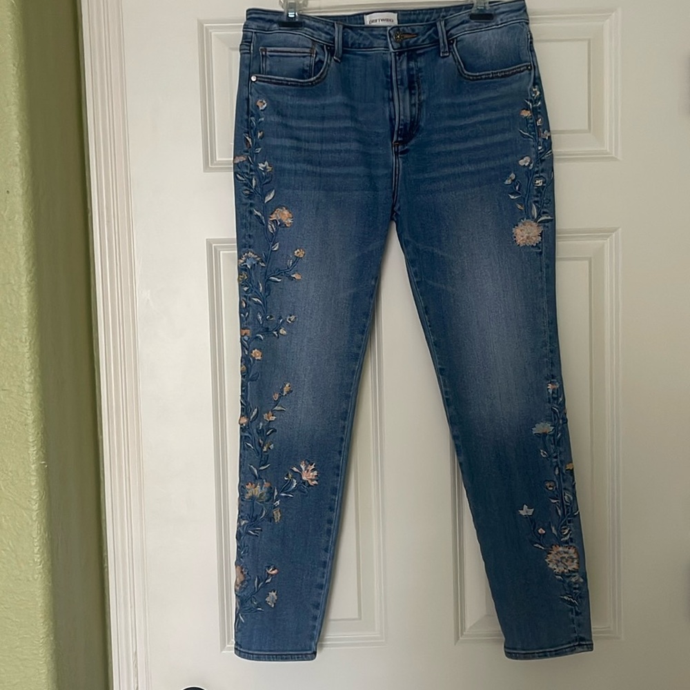 Driftwood denim jeans with embroidered floral detailing.